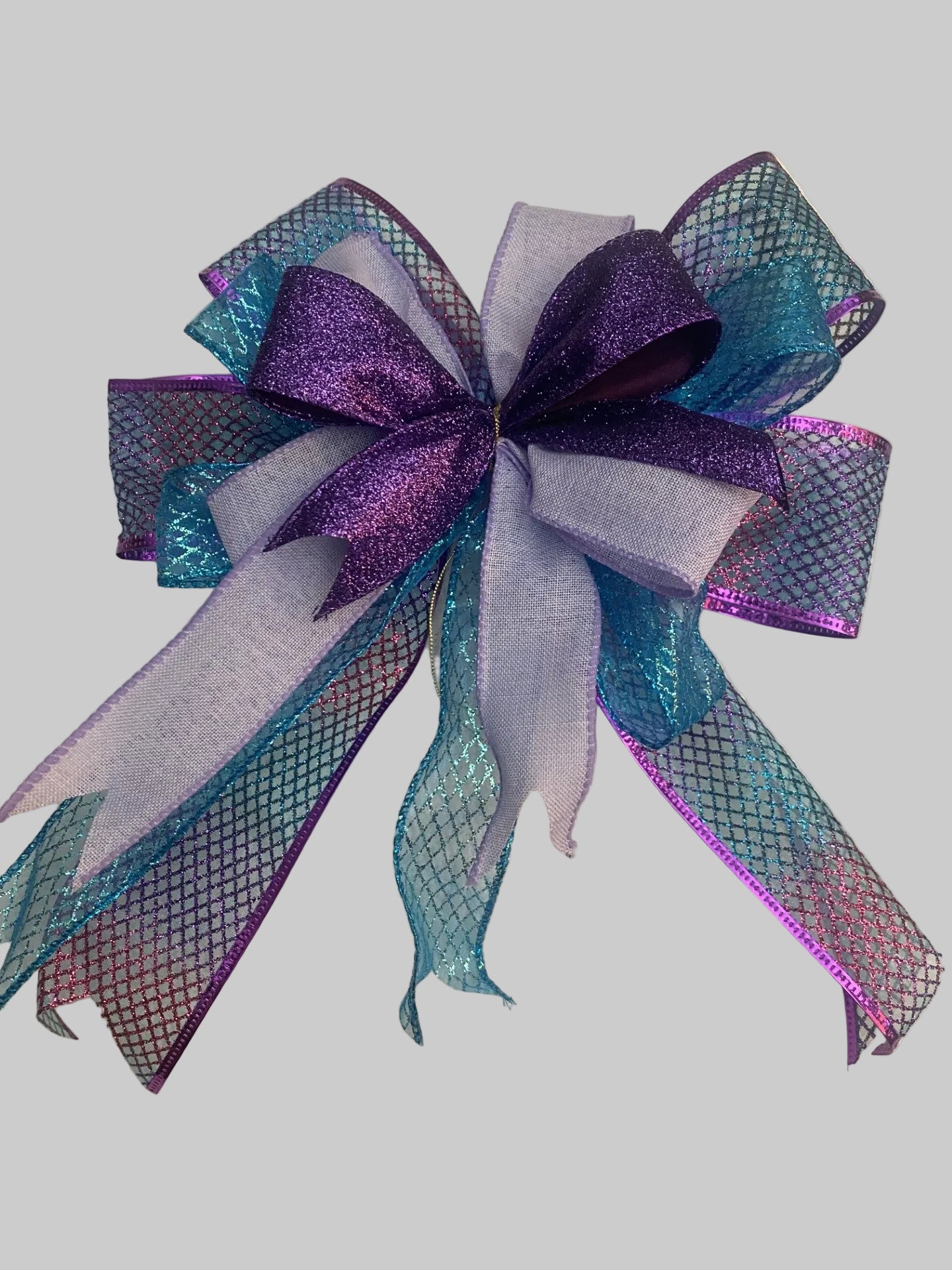 Decorative bow with purple and blue hues on a textured surface